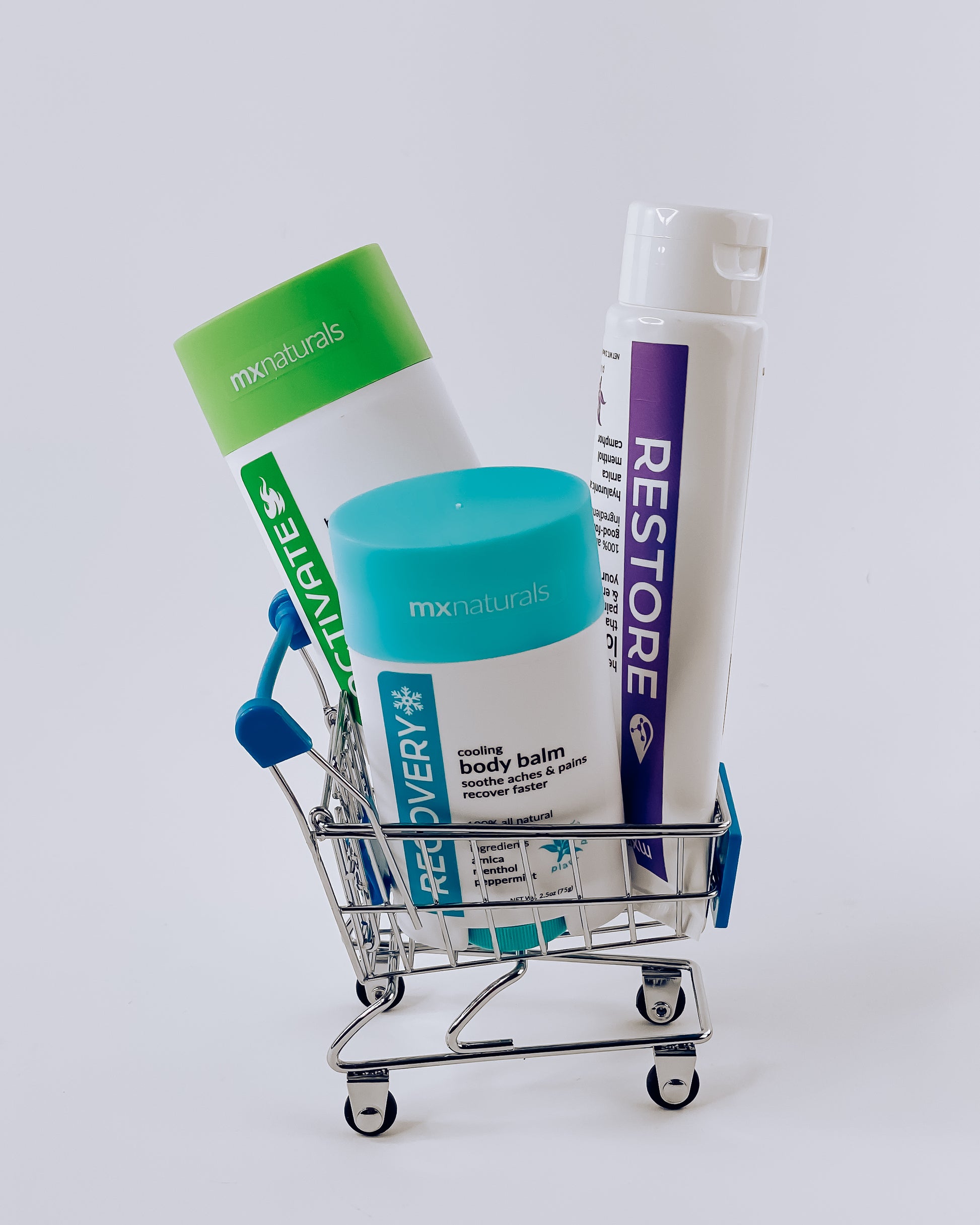 white background with two pain relief balms, activate heated body balm and recovery cooling body balm, in a tiny shopping cart with a tube of restore targeted healing lotion 